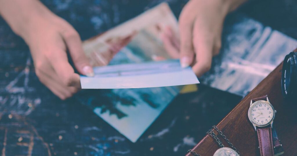 手紙をそっと広げる手元の写真。静かな光の中で心が揺れる夜のイメージを表す。