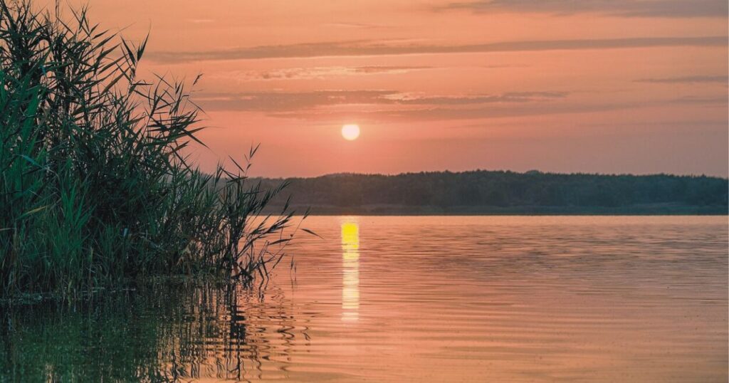 湖面に朝日が映る静かな夜明けの風景