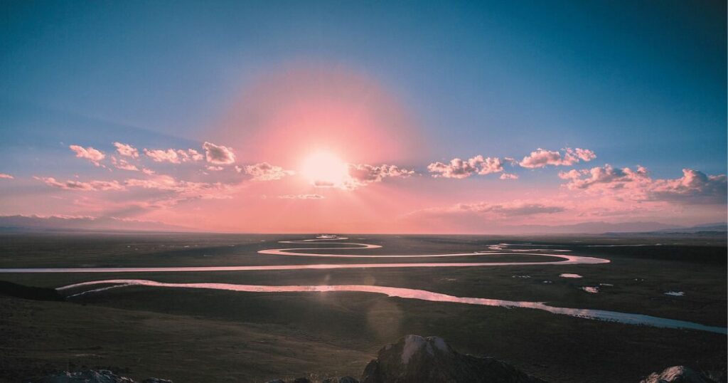 朝日が静かに差し込む川の風景。やさしい時間の流れを感じる穏やかなイメージ。