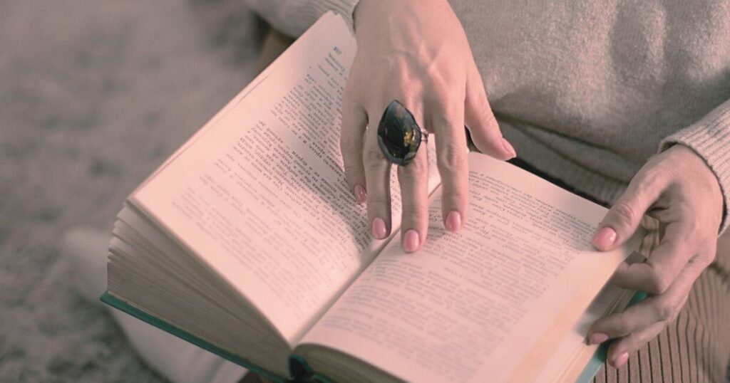 本を開きながら静かに気持ちを落ち着ける女性の手元の写真