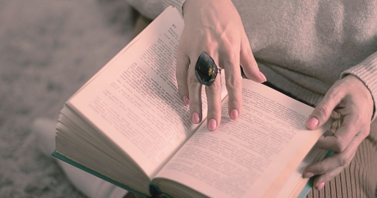 本を開きながら静かに気持ちを落ち着ける女性の手元の写真