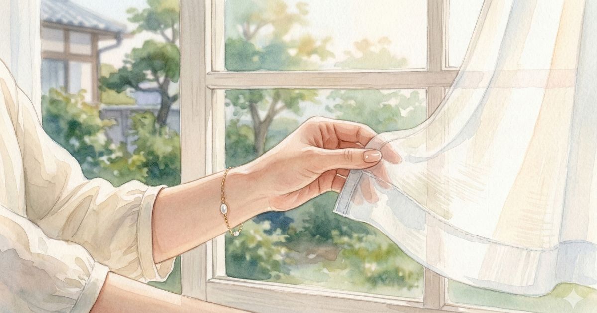 窓辺で女性の手が白いカーテンをそっと引き、外の緑の景色を眺める静かな朝の光